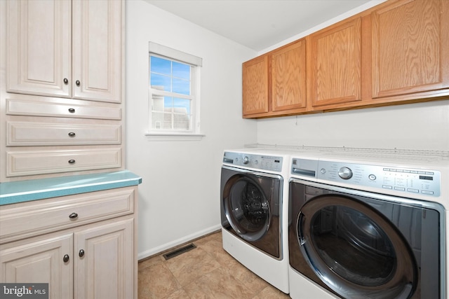 washroom featuring cabinets and washer and dryer