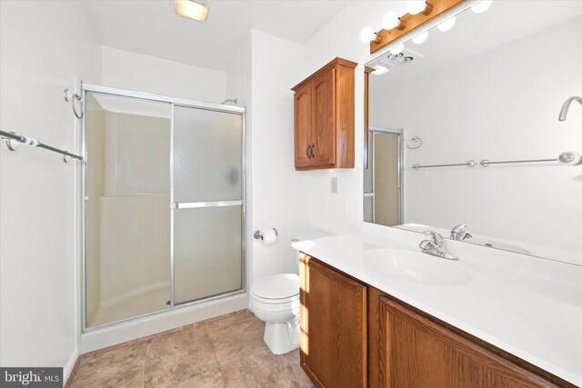 bathroom with vanity, a shower with shower door, and toilet