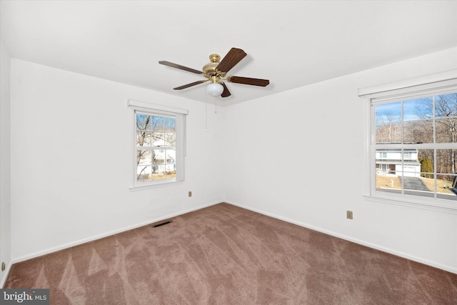 unfurnished room featuring ceiling fan, carpet, and a wealth of natural light