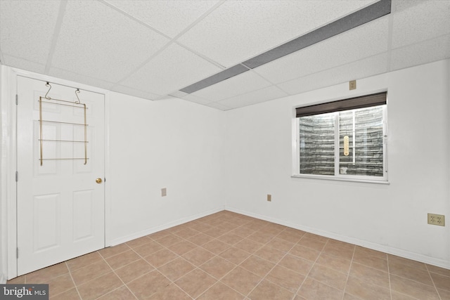 spare room featuring light tile patterned floors and a paneled ceiling