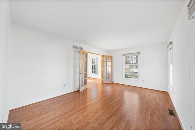 empty room featuring light hardwood / wood-style flooring and french doors