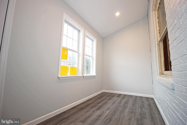 unfurnished room with lofted ceiling and dark wood-type flooring