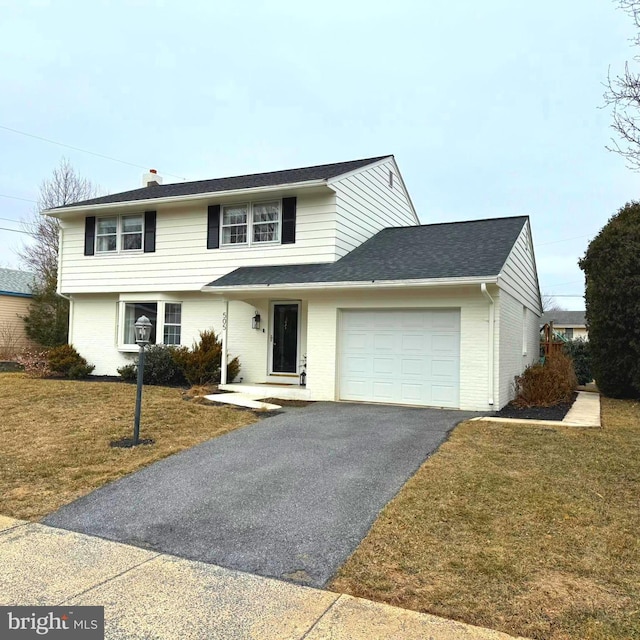 view of front of house with a shingled roof, brick siding, driveway, a garage, and a front yard