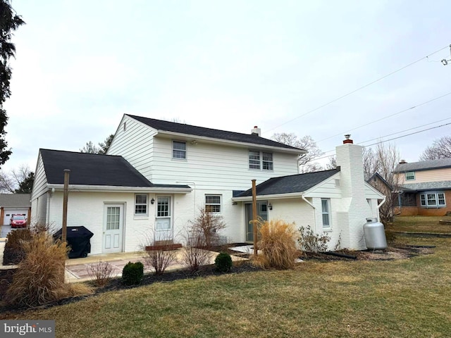 rear view of property with a patio, a lawn, and brick siding