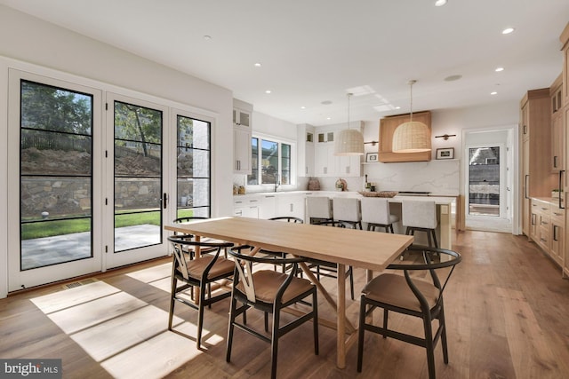 dining area with sink and light hardwood / wood-style floors