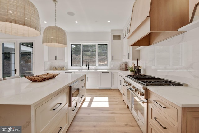 kitchen with appliances with stainless steel finishes, premium range hood, hanging light fixtures, a center island, and light stone countertops