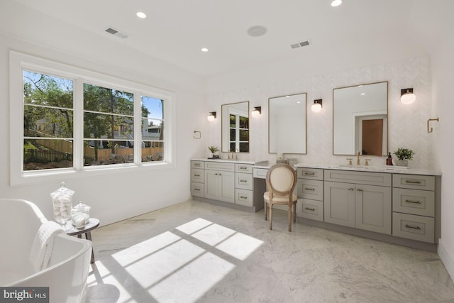 bathroom with vanity and a washtub