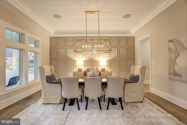 dining area featuring crown molding, a chandelier, and light wood-type flooring