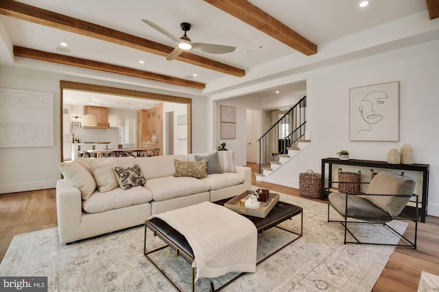 living room with beam ceiling, light hardwood / wood-style flooring, and ceiling fan