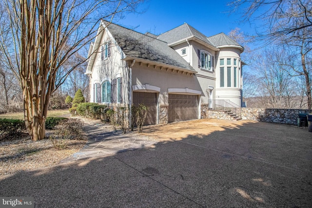 7024 Green Oak Dr, Mclean, VA 22101 - view of side of home featuring stucco siding, driveway, a shingled roof, an attached garage, and stone siding