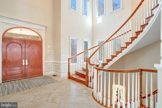 7024 Green Oak Dr, Mclean, VA 22101 - foyer entrance with a towering ceiling, stairs, a wainscoted wall, a decorative wall, and tile patterned flooring