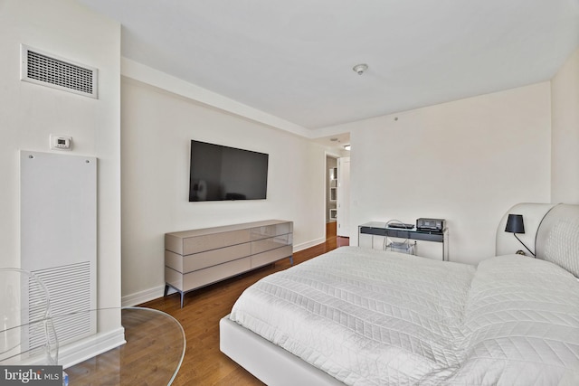 bedroom with dark hardwood / wood-style flooring