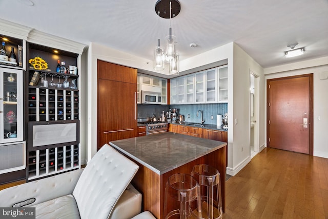 kitchen featuring decorative light fixtures, sink, a breakfast bar area, a center island, and stainless steel appliances