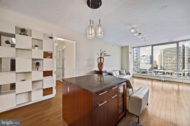 kitchen featuring pendant lighting, dark hardwood / wood-style flooring, rail lighting, and expansive windows