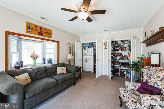 carpeted living room with visible vents and ceiling fan