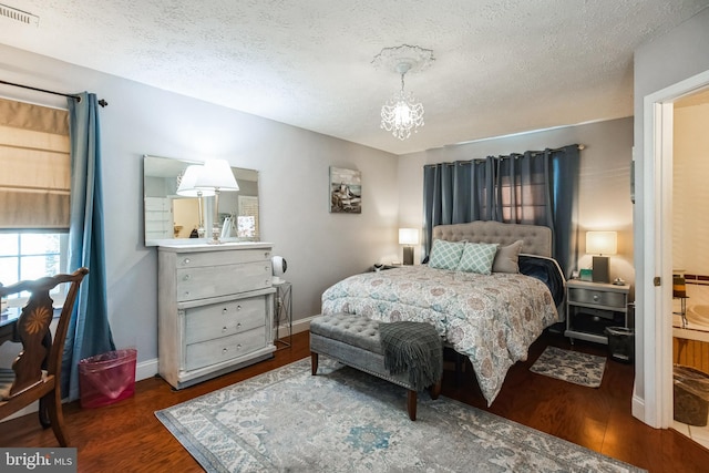 bedroom featuring visible vents, a textured ceiling, wood finished floors, a chandelier, and baseboards