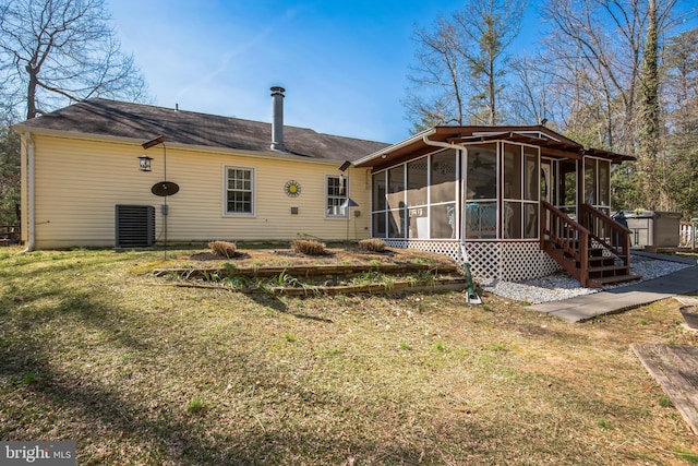 rear view of house featuring a sunroom and a yard