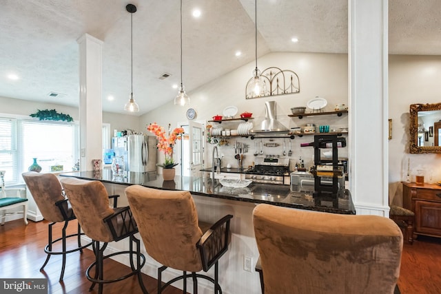 kitchen with lofted ceiling, appliances with stainless steel finishes, dark wood-type flooring, extractor fan, and a sink