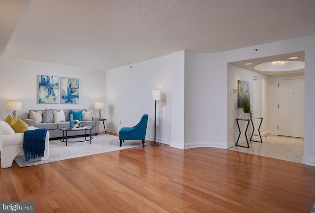 living room featuring a textured ceiling and light hardwood / wood-style flooring