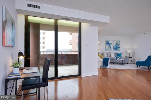 office featuring hardwood / wood-style flooring, ornamental molding, and a textured ceiling