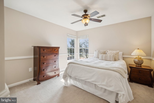 bedroom featuring ceiling fan, visible vents, baseboards, and light colored carpet