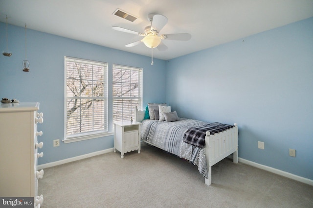 bedroom featuring baseboards, visible vents, a ceiling fan, and light colored carpet