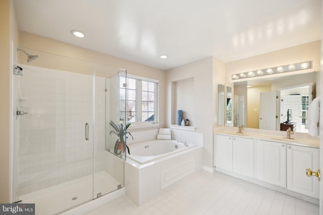 bathroom featuring double vanity, a bath, a shower stall, a sink, and recessed lighting