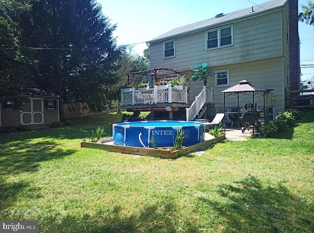 back of property featuring a swimming pool side deck, a lawn, a pergola, a gazebo, and a storage shed