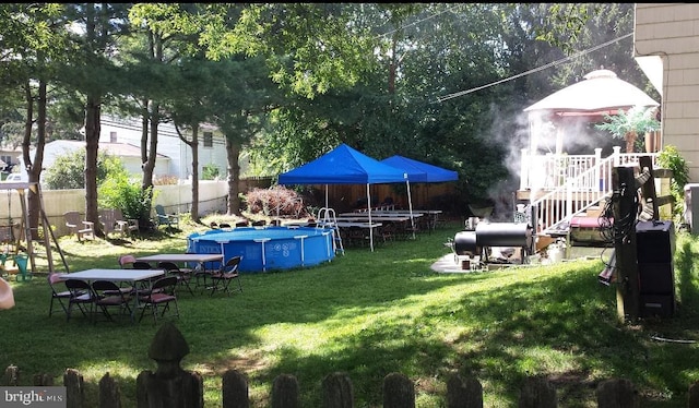 view of yard with a fenced in pool, a gazebo, and a playground