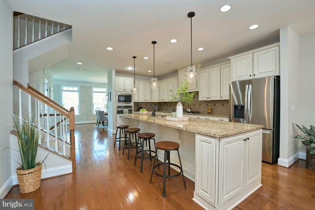 7916 Culloden Crest Ln, Gainesville, VA 20155 - kitchen with stainless steel appliances, wood-type flooring, recessed lighting, a spacious island, and white cabinetry