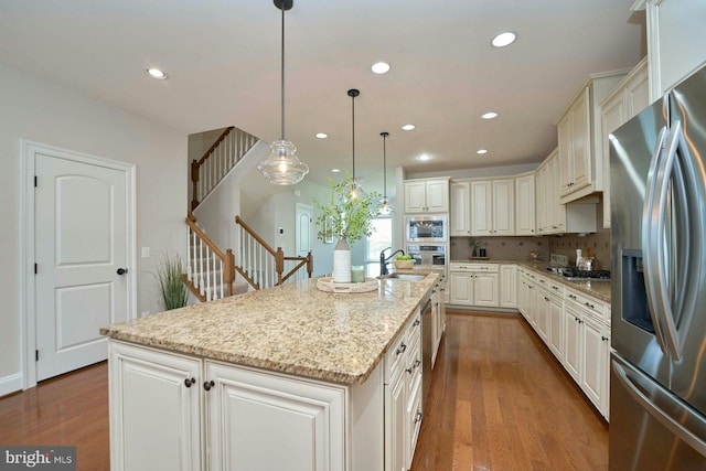 7916 Culloden Crest Ln, Gainesville, VA 20155 - kitchen featuring stainless steel appliances, wood finished floors, recessed lighting, a kitchen island with sink, and light stone countertops