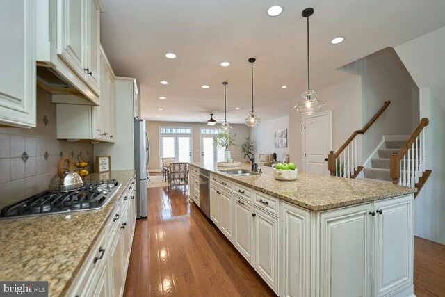 7916 Culloden Crest Ln, Gainesville, VA 20155 - kitchen featuring appliances with stainless steel finishes, recessed lighting, dark wood finished floors, a large island with sink, and tasteful backsplash