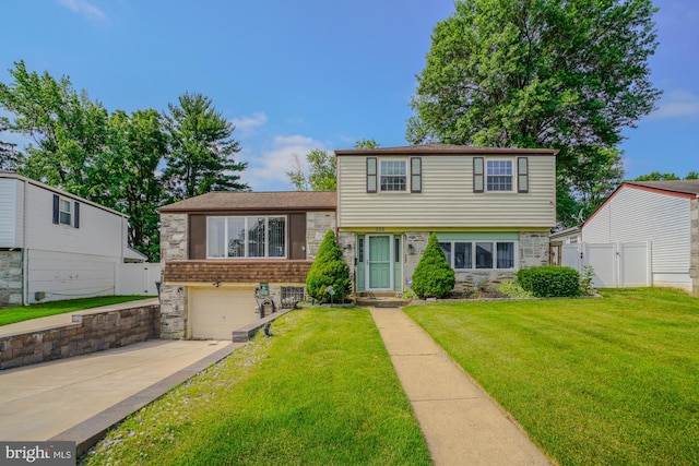 split level home featuring a garage and a front yard