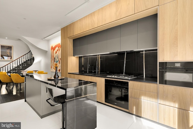 kitchen featuring dark countertops, tasteful backsplash, modern cabinets, and oven