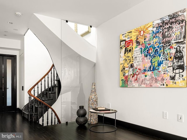 stairway featuring wood finished floors and baseboards