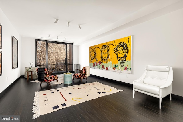 sitting room with expansive windows, wood finished floors, and baseboards