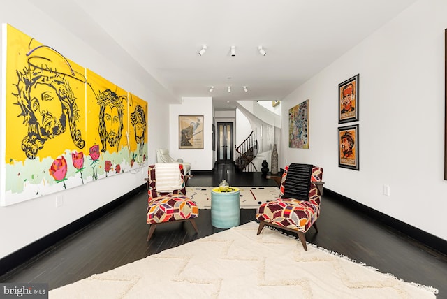 interior space featuring wood finished floors, baseboards, and stairs