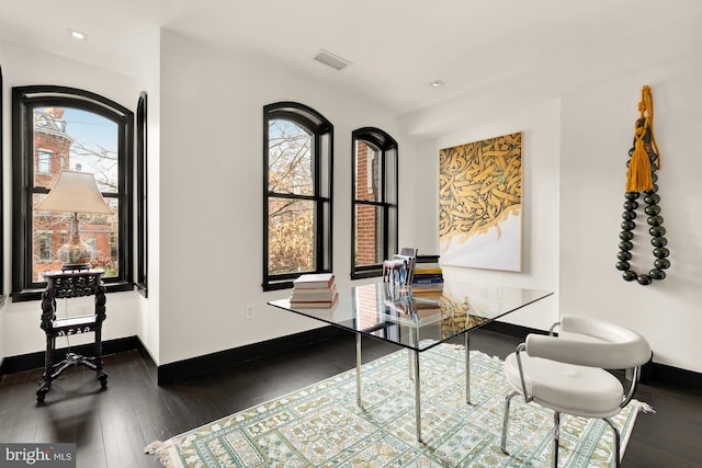 office area with baseboards, visible vents, and hardwood / wood-style floors