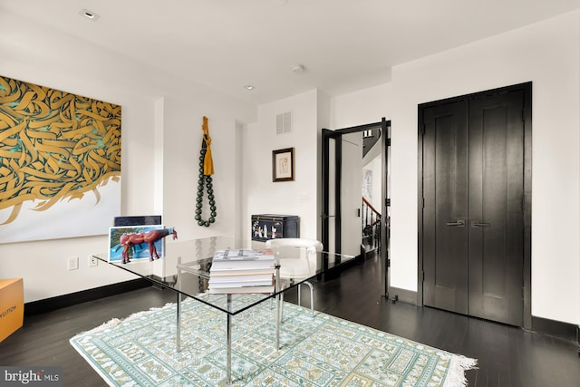 interior space with visible vents, baseboards, and wood finished floors