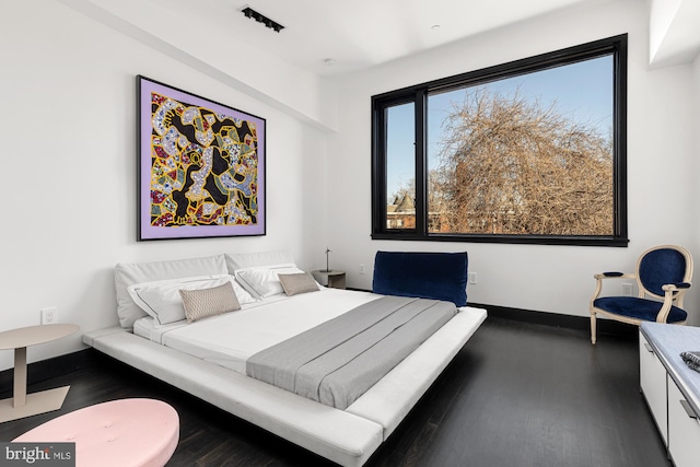 bedroom featuring wood finished floors and baseboards