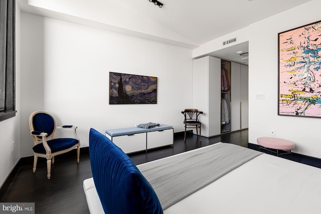 bedroom featuring vaulted ceiling, dark wood-style flooring, visible vents, and baseboards