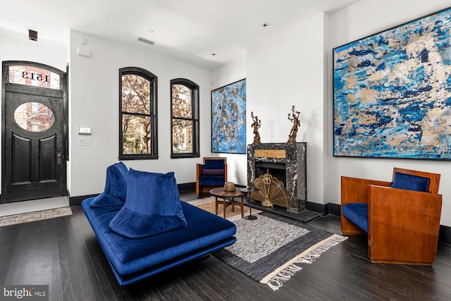 sitting room with baseboards, a fireplace, visible vents, and wood finished floors