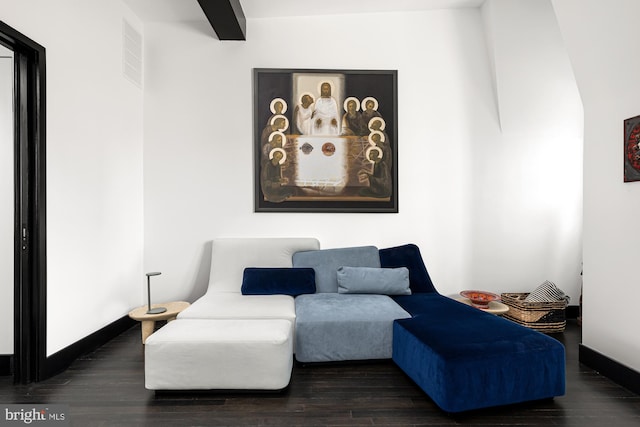 living area with visible vents, beam ceiling, baseboards, and wood finished floors