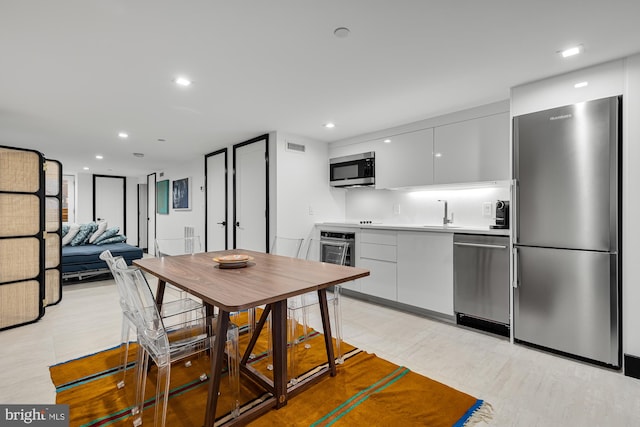 kitchen featuring stainless steel appliances, modern cabinets, visible vents, and recessed lighting