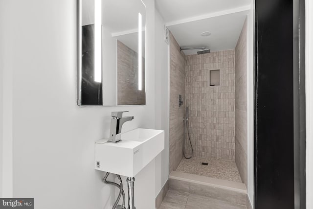 bathroom with visible vents and a tile shower