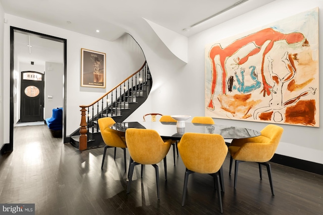 dining space featuring stairs, wood finished floors, and baseboards