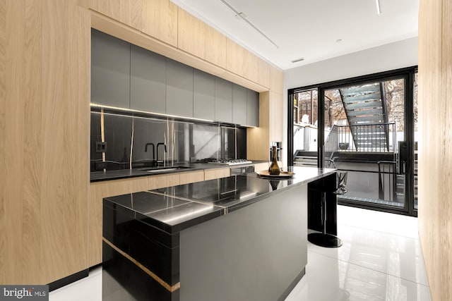 kitchen with modern cabinets, a sink, and decorative backsplash