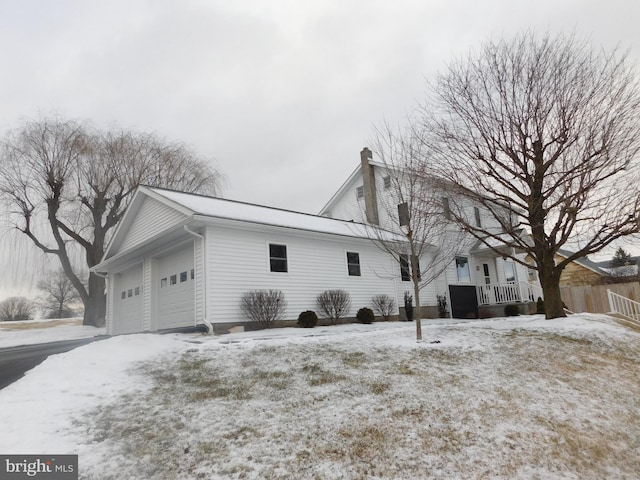 view of snow covered exterior with a garage