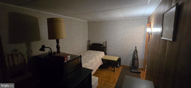 bedroom featuring ornamental molding and parquet flooring