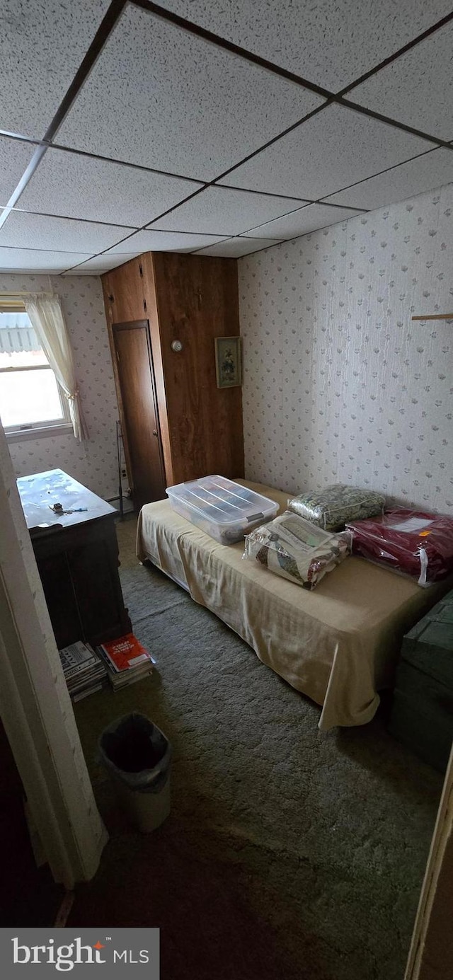 carpeted bedroom with a drop ceiling